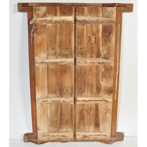 945 - An early 20th Century Indian hand carved solid teak wood door. Small form with two doors with carved... 
