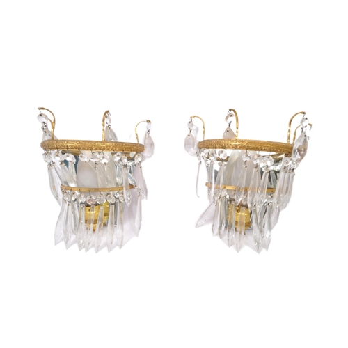 961 - A pair of early 20th Century gilt metal wall lights. Having loose mirror back with decorated gilt me... 