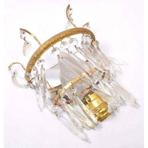 961 - A pair of early 20th Century gilt metal wall lights. Having loose mirror back with decorated gilt me... 