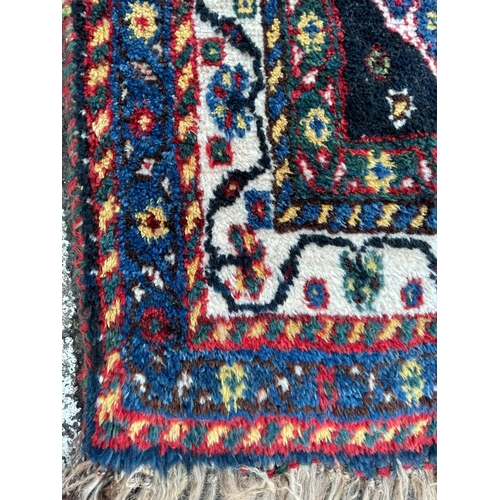931 - An early 20th Century Gashai Persian Islamic carpet floor rug. Having virgin pile wool with red and ... 