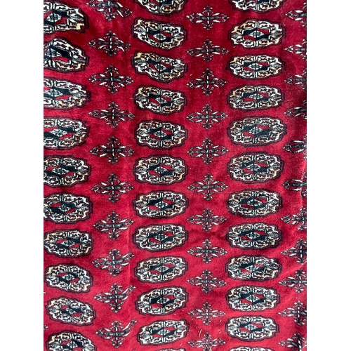 950 - A vintage 20th Century Bucahra Persian Islamic carpet floor rug. Having repeating central medallions... 