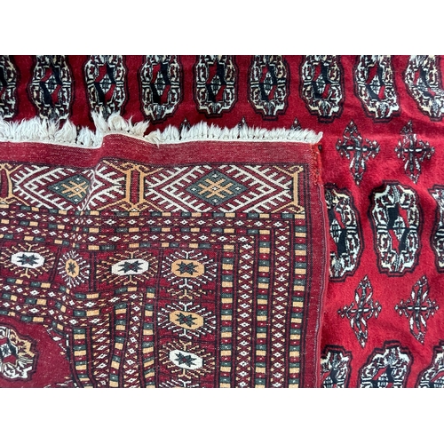 950 - A vintage 20th Century Bucahra Persian Islamic carpet floor rug. Having repeating central medallions... 