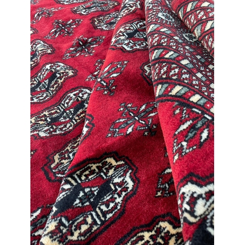 950 - A vintage 20th Century Bucahra Persian Islamic carpet floor rug. Having repeating central medallions... 