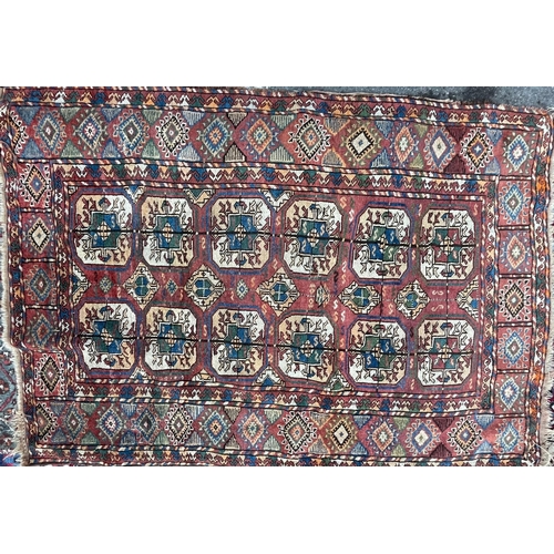 975 - A vintage early 20th Century Afghan Bukara Persian Islamic carpet floor rug. Having repeating medall... 
