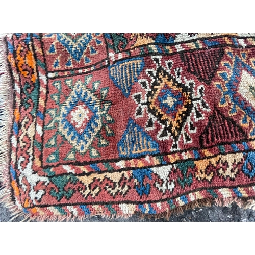 975 - A vintage early 20th Century Afghan Bukara Persian Islamic carpet floor rug. Having repeating medall... 
