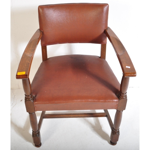 1043 - A mid 20th century circa. 1940's carver desk chair. The chair having oak arm rests over seat and bac... 