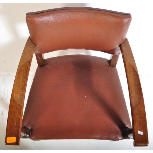 1043 - A mid 20th century circa. 1940's carver desk chair. The chair having oak arm rests over seat and bac... 