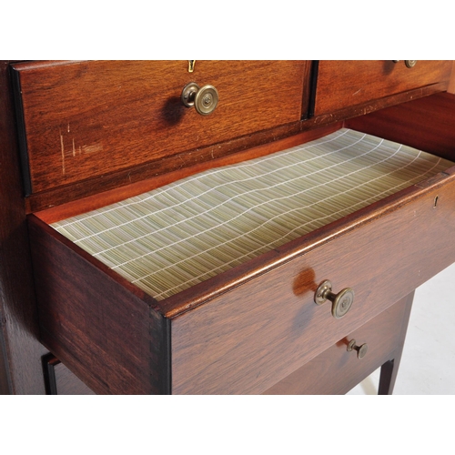 1050 - A mid century Air Ministry style mahogany chest of drawers. Raised on stile supports with 2 short ov... 