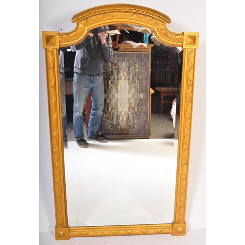 1051 - A large early 20th Century circa 1920s wooden gilt frame bevelled edge over mantel mirror. Having an... 