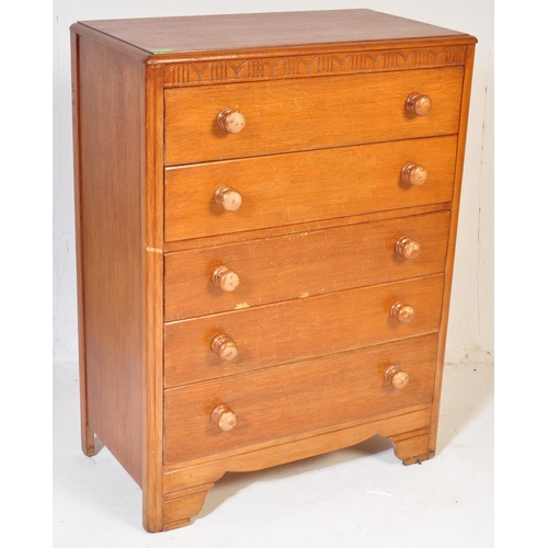 599 - A vintage 20th century circa 1940s light oak chest of drawers having a carved floral frieze over a b... 