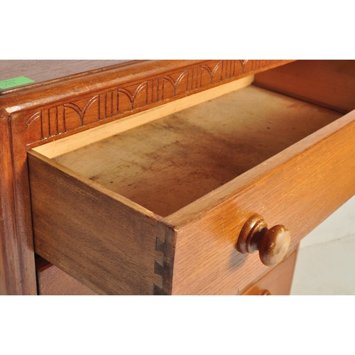 599 - A vintage 20th century circa 1940s light oak chest of drawers having a carved floral frieze over a b... 