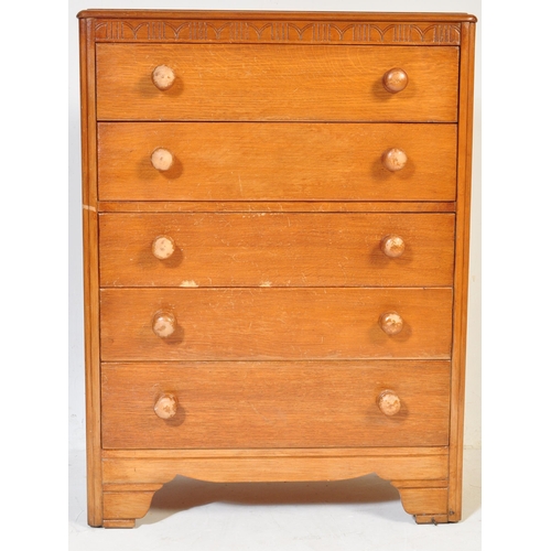599 - A vintage 20th century circa 1940s light oak chest of drawers having a carved floral frieze over a b... 