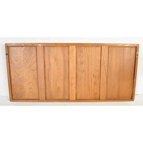 619 - Ercol - A vintage retro mid 20th century light elm wall mounted Ercol plate rack having two bowed sh... 