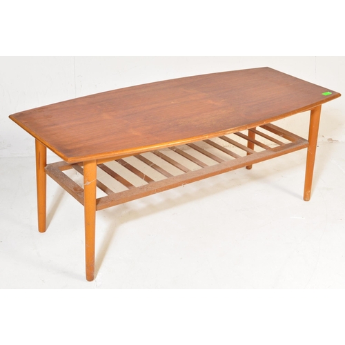 775 - A vintage retro mid 20th century teak surfboard coffee table having a shaped top with rail under tie... 