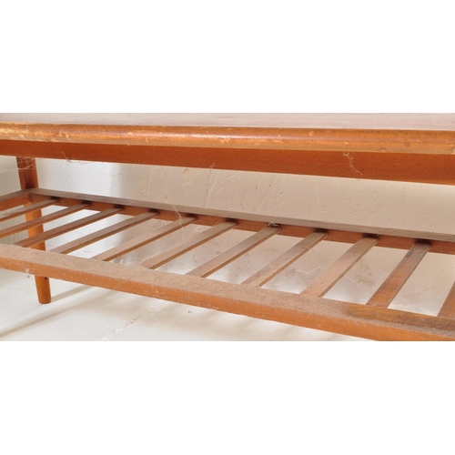 775 - A vintage retro mid 20th century teak surfboard coffee table having a shaped top with rail under tie... 