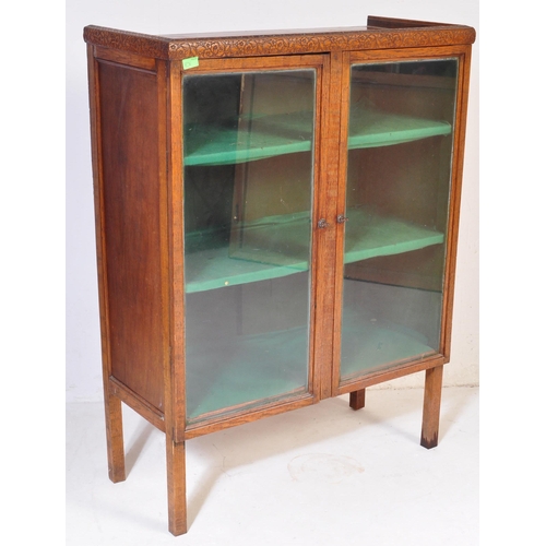 856 - A vintage 20th century 1930's oak glazed cabinet having twin doors opening to reveal a shelved inter... 