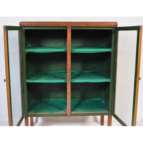 856 - A vintage 20th century 1930's oak glazed cabinet having twin doors opening to reveal a shelved inter... 