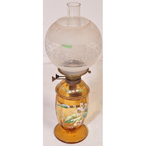 927 - An early 20th century glass oil lamp having a enamelled decorated reservoir in yellow colourway, wit... 
