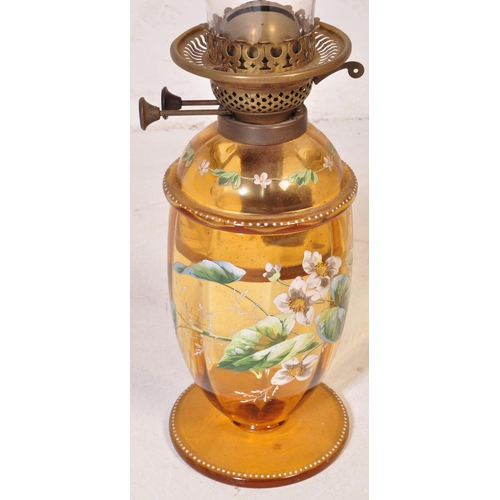 927 - An early 20th century glass oil lamp having a enamelled decorated reservoir in yellow colourway, wit... 