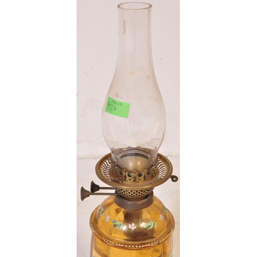 927 - An early 20th century glass oil lamp having a enamelled decorated reservoir in yellow colourway, wit... 