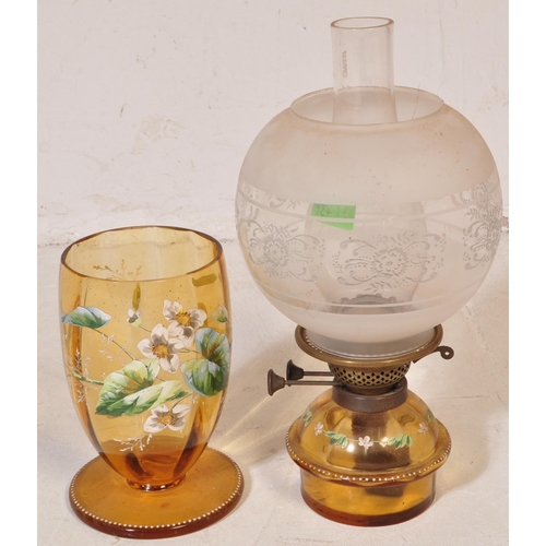 927 - An early 20th century glass oil lamp having a enamelled decorated reservoir in yellow colourway, wit... 