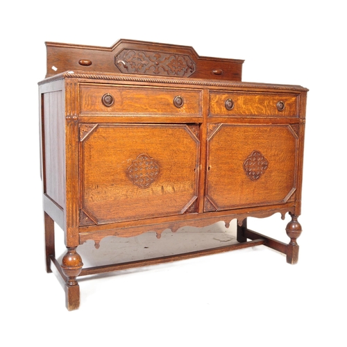 939 - An early 20th century circa. 1920's oak Jacobean Revival sideboard credenza. The sideboard having ga... 