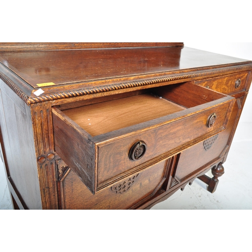 939 - An early 20th century circa. 1920's oak Jacobean Revival sideboard credenza. The sideboard having ga... 