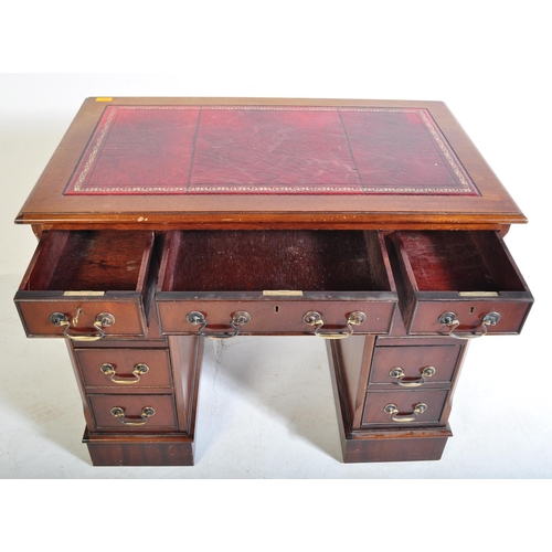 940 - A 20th century George III mahogany and leather twin pedestal kneehole desk. The kneehole desk  havin... 