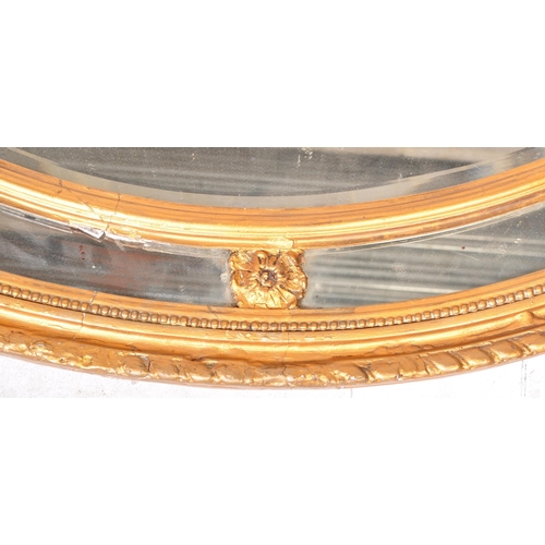 941 - An early 19th Century Regency gilt gesso plaster overmantel wall mirror of oval form. The central mi... 