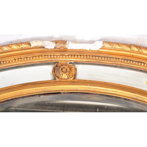 941 - An early 19th Century Regency gilt gesso plaster overmantel wall mirror of oval form. The central mi... 