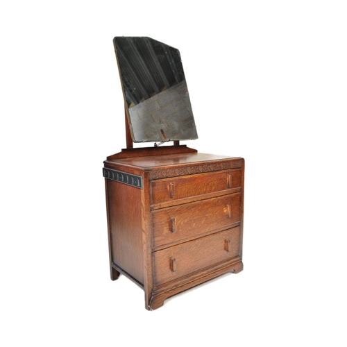 951 - A 20th century Jacobean revival oak dressing chest. The dressing chest being of upright form with ce... 