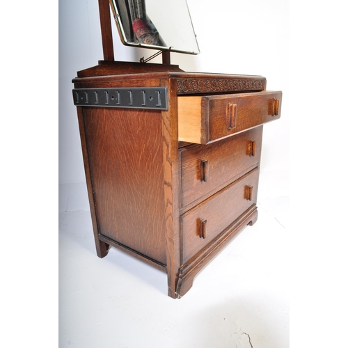 951 - A 20th century Jacobean revival oak dressing chest. The dressing chest being of upright form with ce... 