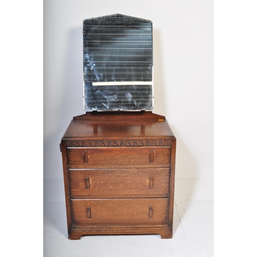 951 - A 20th century Jacobean revival oak dressing chest. The dressing chest being of upright form with ce... 