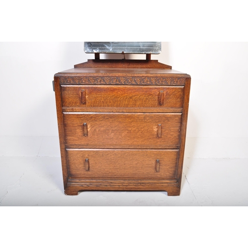 951 - A 20th century Jacobean revival oak dressing chest. The dressing chest being of upright form with ce... 