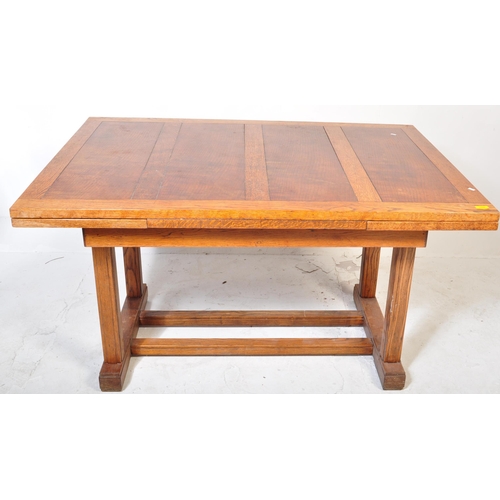 952 - A 1920’s oak Arts & Crafts large draw leaf refectory dining table raised on thick turned supports wi... 