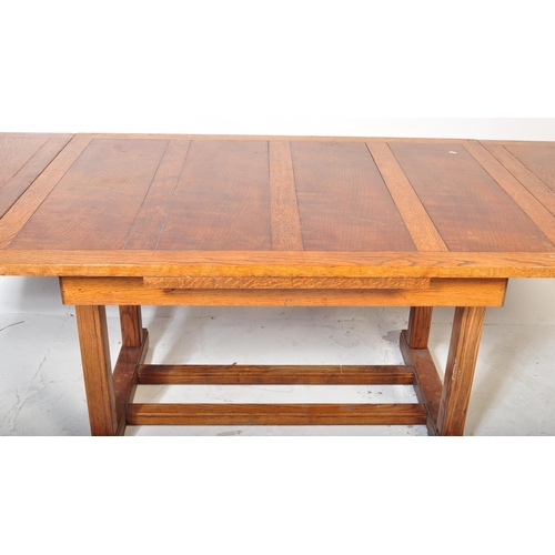 952 - A 1920’s oak Arts & Crafts large draw leaf refectory dining table raised on thick turned supports wi... 