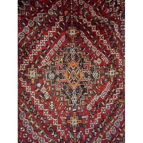 953 - A vintage 20th century Persian Nomadic Qashqai hand knotted floor carpet rug having a dark central m... 