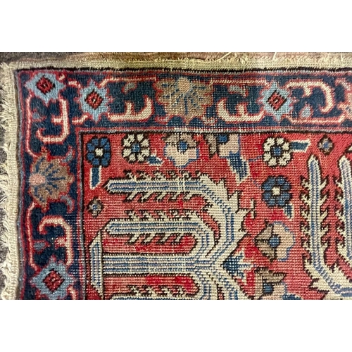 954 - An early 20th century Persian Iran Djoscheghan floor carpet rug having repeating foliate patterns th... 