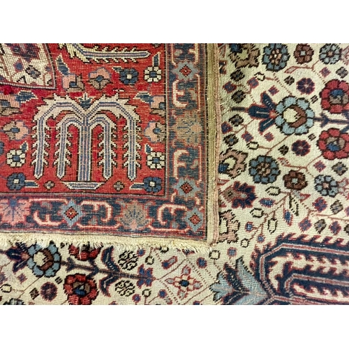 954 - An early 20th century Persian Iran Djoscheghan floor carpet rug having repeating foliate patterns th... 