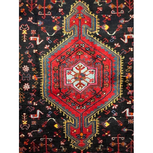 958 - A vintage mid 20th century Persian Islamic Hamadan floor carpet rug having geometric central medalli... 