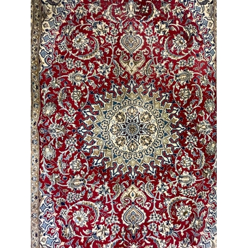 963 - A vintage late 20th century Persian Islamic Nain floor carpet rug having a central sun shaped medall... 