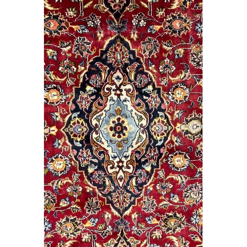972 - A 20th century Central Persian Islamic Kashan floor rug carpet having a central medallion in light b... 