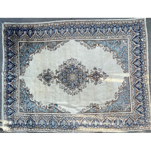 957 - An 20th Century Kirman Persian Islamic floor carpet rug having a central panel in cream and light bl... 