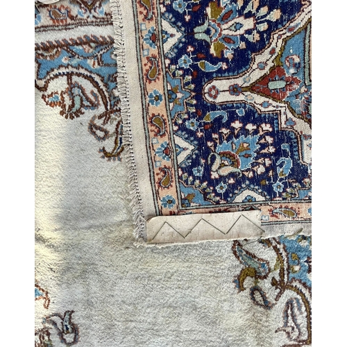 957 - An 20th Century Kirman Persian Islamic floor carpet rug having a central panel in cream and light bl... 