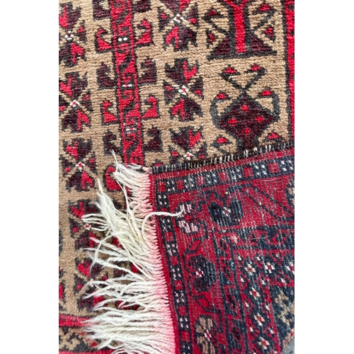 964 - A vintage 20th Century Persian Islamic Baluch prayer floor carpet rug. Having central geometric pane... 