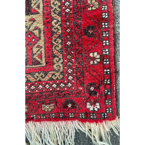 964 - A vintage 20th Century Persian Islamic Baluch prayer floor carpet rug. Having central geometric pane... 