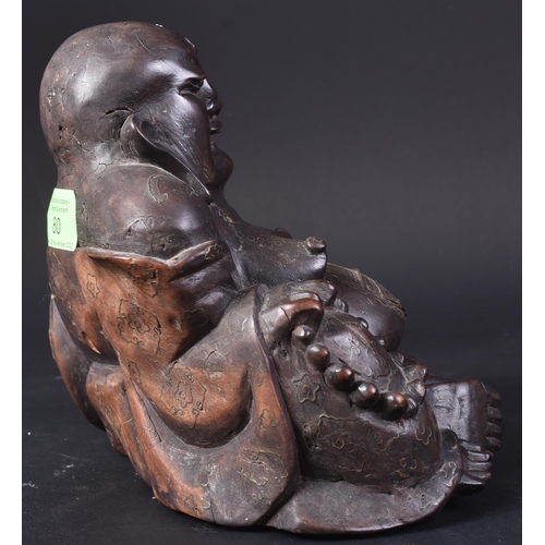 129 - An early 20th Century Chinese hardwood carved figurine of Buddha. The pot bellied figure modelled si... 