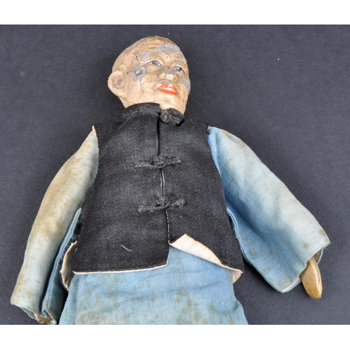 138 - A 19th Century Chinese doll. Painted features to head with hand made robe & jacket and painted shoes... 