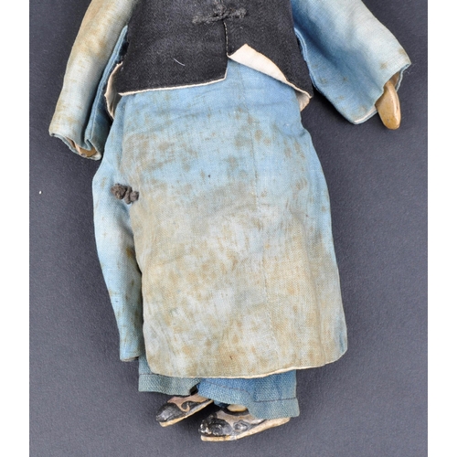 138 - A 19th Century Chinese doll. Painted features to head with hand made robe & jacket and painted shoes... 