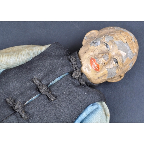 138 - A 19th Century Chinese doll. Painted features to head with hand made robe & jacket and painted shoes... 